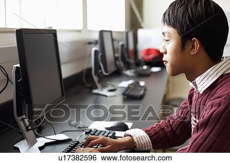 Side profile of a businessman using a computer View Large Photo Image Stock Photograph - Side profile of a businessman using a computer. Fotosearch