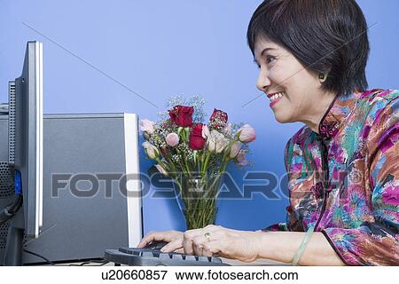 Side profile of a senior woman using a computer and smiling View Large Photo Image Stock Photo - Side profile of a senior woman using a computer and smiling. Fotosearch