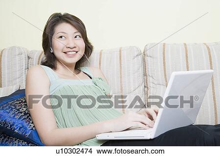 Young woman using a laptop and smiling View Large Photo Image Picture - Young woman using a laptop and smiling. Fotosearch