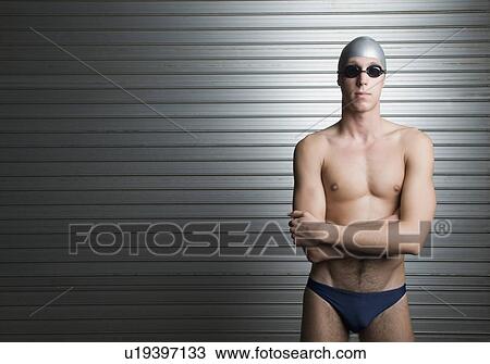 Close-up of a young man standing with his arms crossed View Large Photo Image Stock Image - Close-up of a young man standing with his arms crossed. Fotosearch
