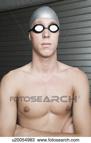 Close-up of a young man standing with his arms crossed View Large Photo Image Stock Image - Close-up of a young man standing with his arms crossed. Fotosearch