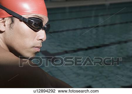Stock Image - Close-up of a young man wearing swimming goggles. Fotosearch