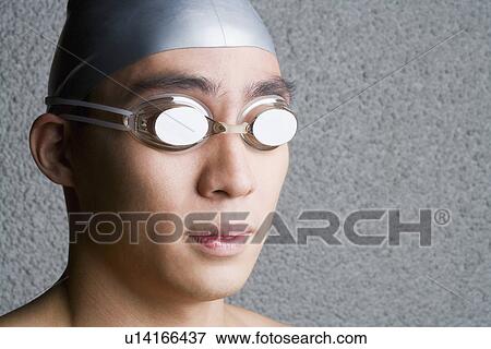 Close-up of a young man wearing swimming goggles View Large Photo Image Stock Photo - Close-up of a young man wearing swimming goggles. Fotosearch