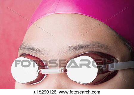Stock Photograph - Close-up of a young woman wearing swimming goggles. Fotosearch