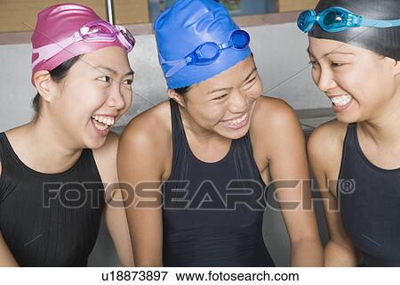 Stock Photo - Close-up of three young women wearing swimwear and smiling. Fotosearch