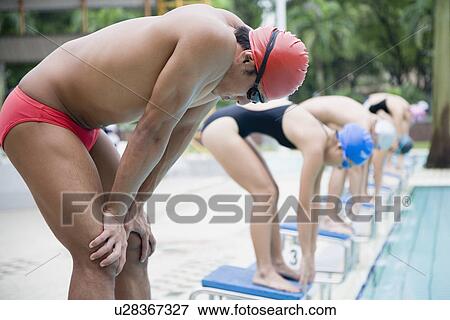 Group of young men and young women standing on starting blocks View Large Photo Image Stock Photo - Group of young men and young women standing on starting blocks. Fotosearch