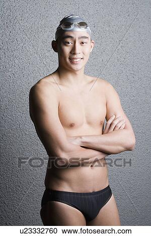 Portrait of a young man standing with his arms crossed View Large Photo Image Stock Image - Portrait of a young man standing with his arms crossed. Fotosearch
