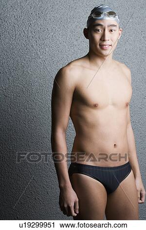 Stock Image - Portrait of a young man wearing racing briefs and smiling. Fotosearch