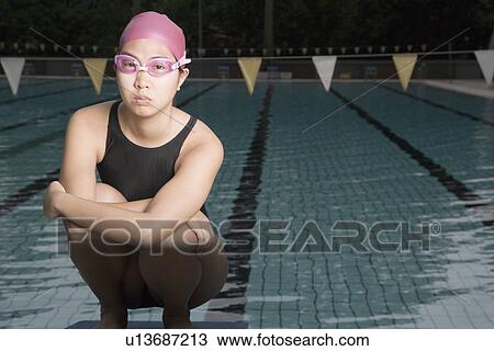 Portrait of a young woman squatting on a starting block View Large Photo Image Stock Image - Portrait of a young woman squatting on a starting block. Fotosearch