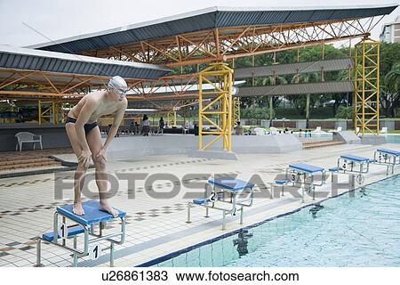 Young man standing on a starting block View Large Photo Image Stock Image - Young man standing on a starting block. Fotosearch