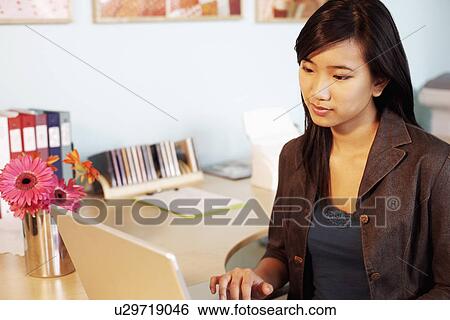 Close-up of a businesswoman using a laptop View Large Photo Image Stock Photograph - Close-up of a businesswoman using a laptop. Fotosearch
