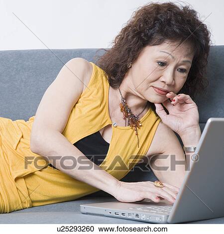 Stock Image - Close-up of a senior woman using a laptop. Fotosearch