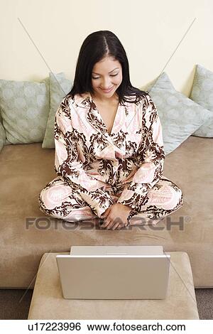 High angle view of a young woman sitting in front of a laptop View Large Photo Image Stock Photograph - High angle view of a young woman sitting in front of a laptop. Fotosearch