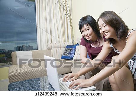 Mature woman and her daughter using a laptop and smiling View Large Photo Image Stock Photo - Mature woman and her daughter using a laptop and smiling. Fotosearch