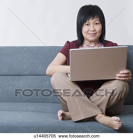 Portrait of a mature woman using a laptop and smiling View Large Photo Image Stock Photography - Portrait of a mature woman using a laptop and smiling. Fotosearch