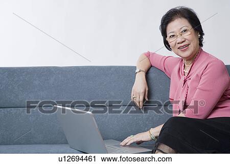 Portrait of a senior woman using a laptop View Large Photo Image Stock Image - Portrait of a senior woman using a laptop. Fotosearch