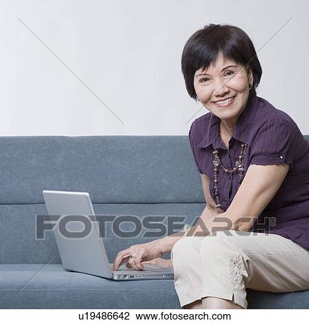 Portrait of a senior woman using a laptop and smiling View Large Photo Image Stock Image - Portrait of a senior woman using a laptop and smiling. Fotosearch