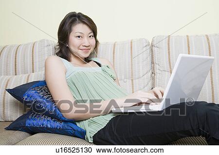 Portrait of a young woman using a laptop and smiling View Large Photo Image Stock Image - Portrait of a young woman using a laptop and smiling. Fotosearch