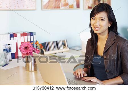 Portrait of a young woman using laptops View Large Photo Image Stock Image - Portrait of a young woman using laptops. Fotosearch
