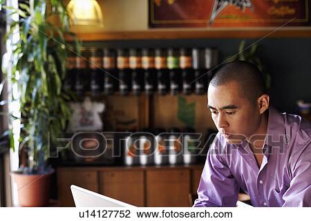 Young man using a laptop View Large Photo Image Stock Image - Young man using a laptop. Fotosearch