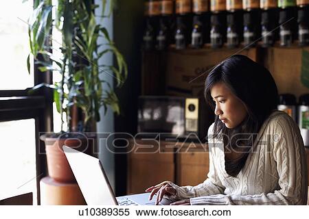 Young woman using a laptop View Large Photo Image Stock Photography - Young woman using a laptop. Fotosearch