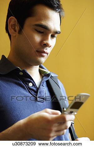 Close-up of a young man holding a mobile phone View Large Photo Image Stock Photo - Close-up of a young man holding a mobile phone. Fotosearch