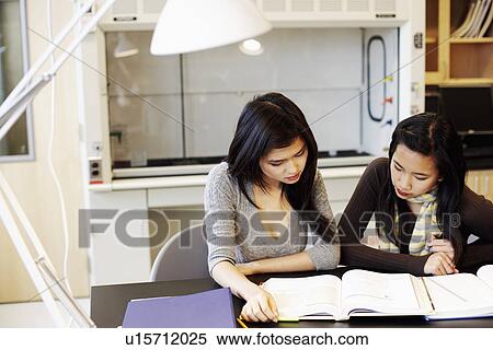 Stock Photography - Close-up of two young women sitting at a table and studying. Fotosearch