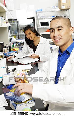 Portrait of a male pharmacist and a female pharmacist working in an laboratory View Large Photo Image Stock Image - Portrait of a male pharmacist and a female pharmacist working in an laboratory. Fotosearch