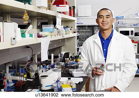 Portrait of a male pharmacist holding a bottle in a laboratory View Large Photo Image Stock Image - Portrait of a male pharmacist holding a bottle in a laboratory. Fotosearch