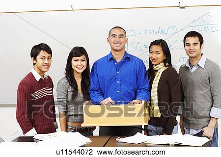 Portrait of a professor standing with his students in the classroom View Large Photo Image Stock Image - Portrait of a professor standing with his students in the classroom. Fotosearch