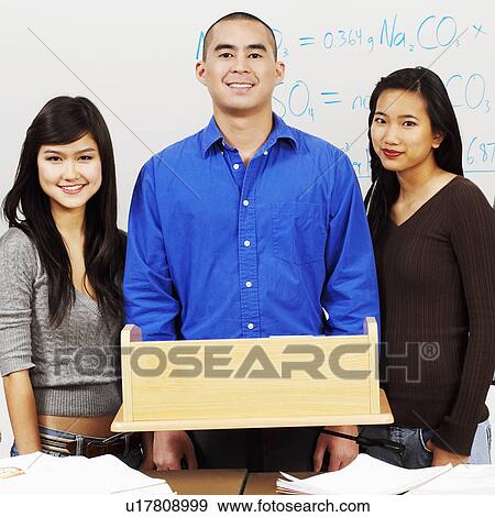 Portrait of a professor standing with his students in the classroom View Large Photo Image Stock Photo - Portrait of a professor standing with his students in the classroom. Fotosearch