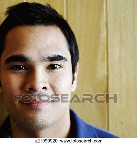 Stock Image - Portrait of a young man smirking. Fotosearch