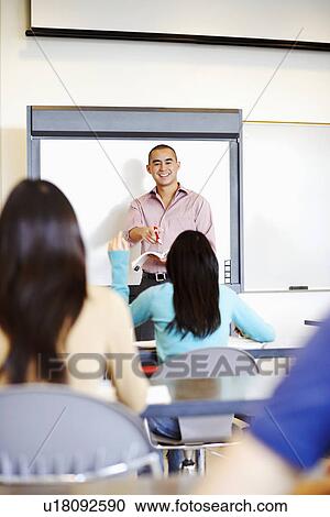 Professor teaching his students in a classroom View Large Photo Image Stock Image - Professor teaching his students in a classroom. Fotosearch