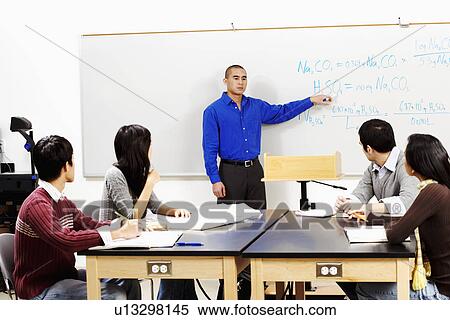 Professor teaching his students in a classroom View Large Photo Image Stock Photography - Professor teaching his students in a classroom. Fotosearch