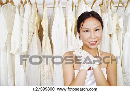 Stock Image - Portrait of a young woman wearing a wedding dress and smiling. Fotosearch