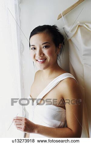 Portrait of a young woman wearing a wedding dress and smiling View Large Photo Image Stock Photo - Portrait of a young woman wearing a wedding dress and smiling. Fotosearch
