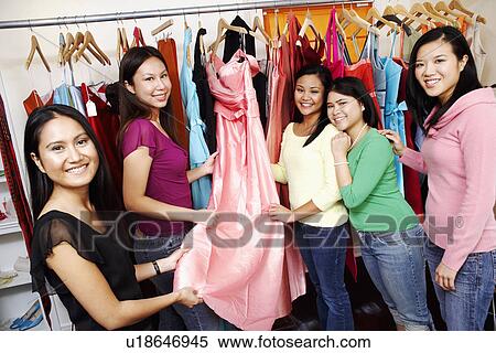 Stock Photography - Portrait of five young women standing in a clothing store. Fotosearch