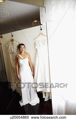 Reflection of a young woman wearing a wedding dress and smiling View Large Photo Image Stock Photography - Reflection of a young woman wearing a wedding dress and smiling. Fotosearch