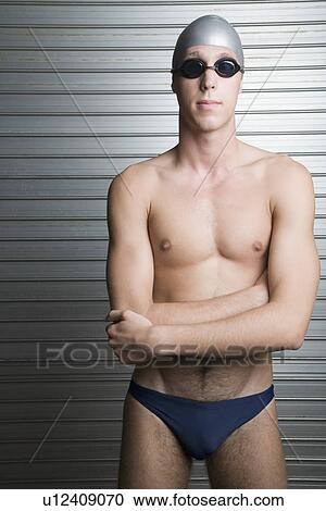 Close-up of a young man standing with his arms crossed View Large Photo Image Stock Image - Close-up of a young man standing with his arms crossed. Fotosearch