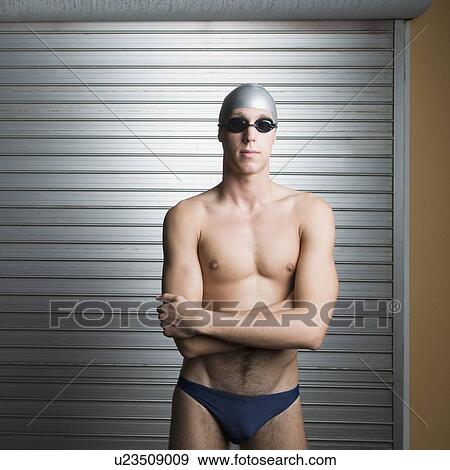 Close-up of a young man standing with his arms crossed View Large Photo Image Stock Photo - Close-up of a young man standing with his arms crossed. Fotosearch