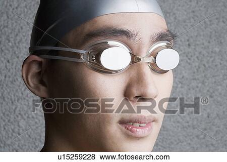Close-up of a young man wearing swimming goggles View Large Photo Image Stock Photo - Close-up of a young man wearing swimming goggles. Fotosearch