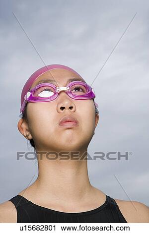 Stock Image - Close-up of a young woman wearing swimming goggles. Fotosearch