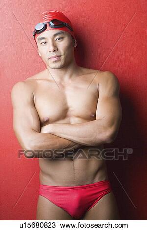 Portrait of a young man standing with his arms crossed View Large Photo Image Stock Image - Portrait of a young man standing with his arms crossed. Fotosearch