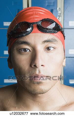 Stock Photo - Portrait of a young man wearing swimming cap. Fotosearch