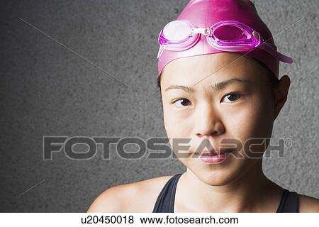 Stock Photo - Portrait of a young woman wearing a swimming cap. Fotosearch