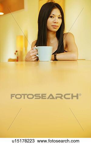 Portrait of a young woman holding a tea cup View Large Photo Image Stock Image - Portrait of a young woman holding a tea cup. Fotosearch