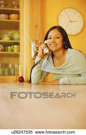 Portrait of a young woman using a telephone and smiling View Large Photo Image Stock Photography - Portrait of a young woman using a telephone and smiling. Fotosearch