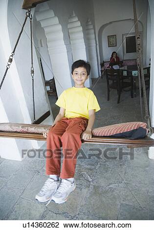 Boy swinging on a swing View Large Photo Image Stock Image - Boy swinging on a swing. Fotosearch