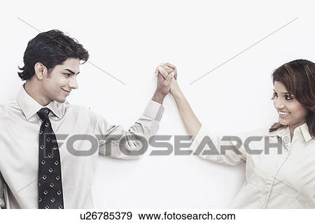 Businessman and a businesswoman holding hands looking at each other View Large Photo Image Stock Photo - Businessman and a businesswoman holding hands looking at each other. Fotosearch