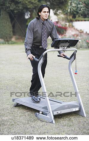 Stock Photo - Businessman exercising on a treadmill. Fotosearch